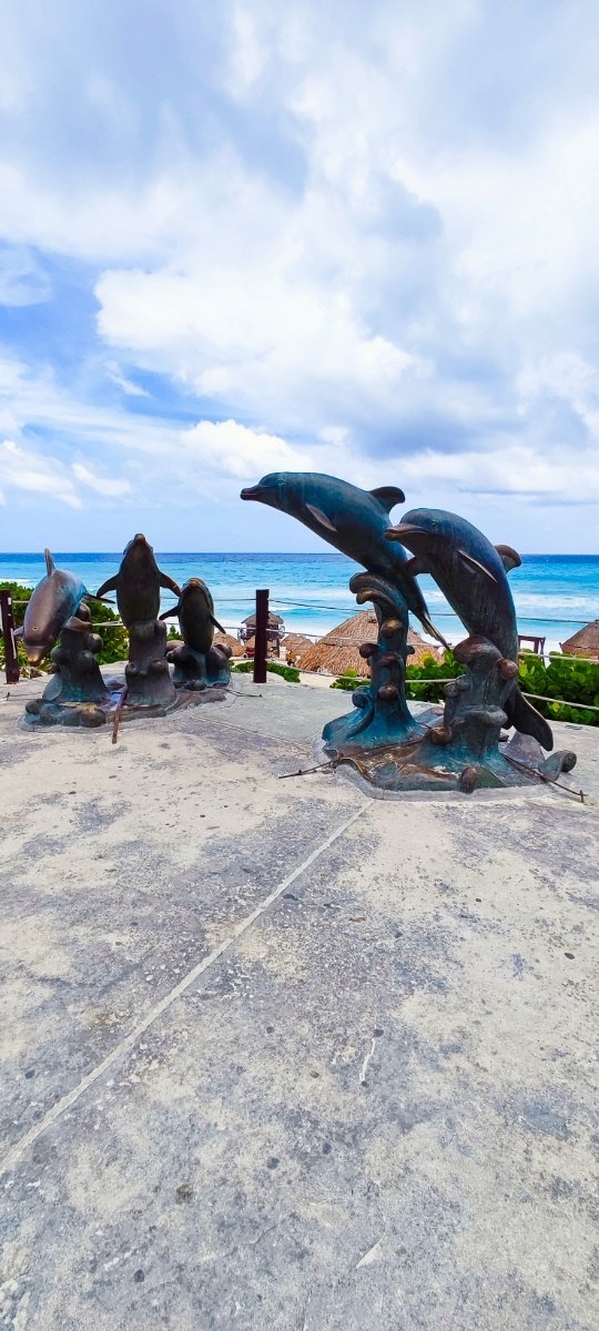 Escultura de delfines de metal cerca del del oceáno en Playa Delfines. © 2024 Castor Daniel Oregel Maldonado